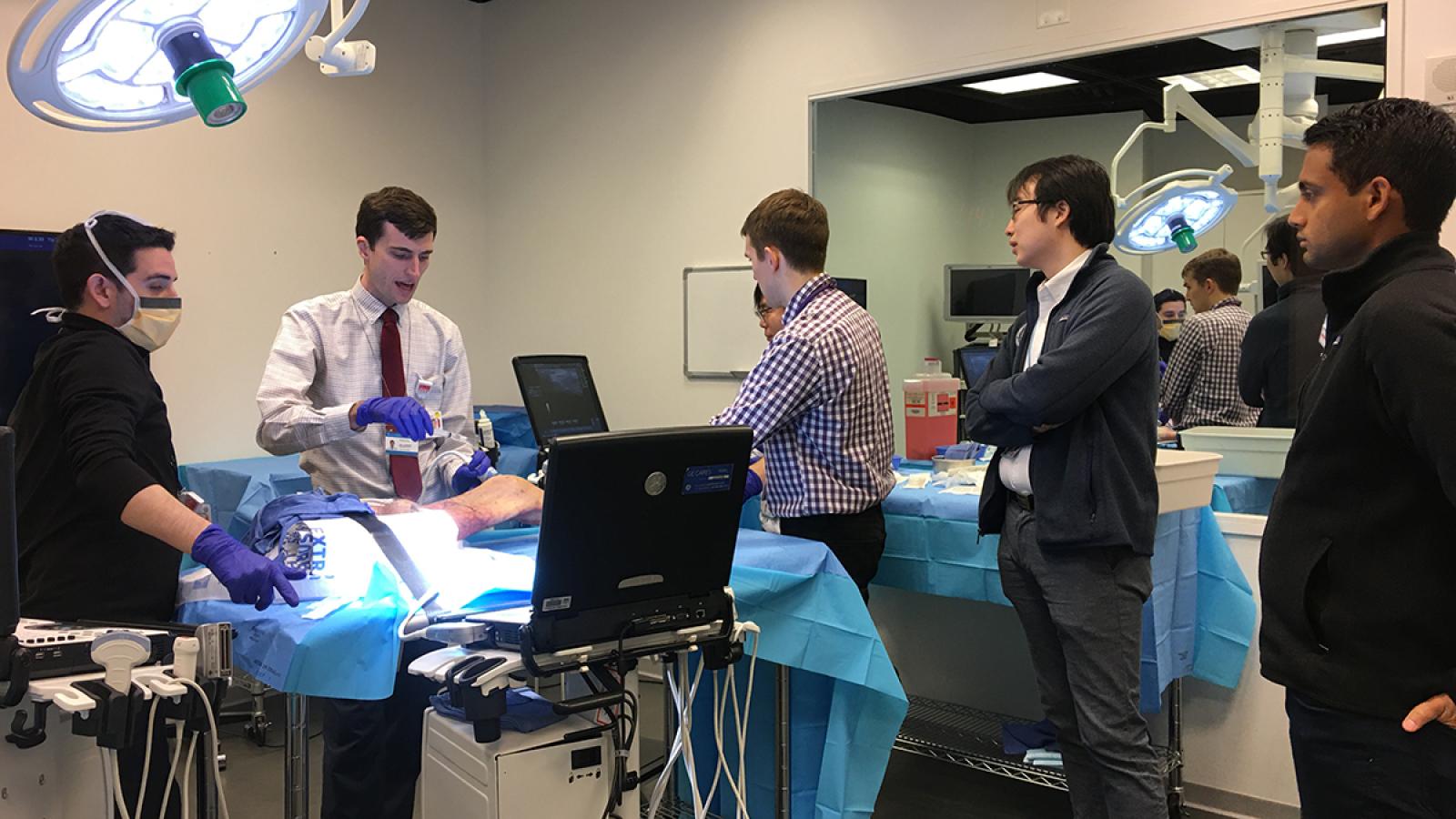 Rheumatology fellows observe sim center demonstration.