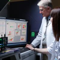 Doctor and fellow look at computer screen.