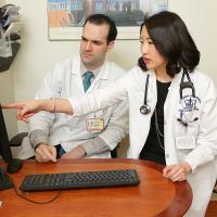 Rheumatologist and fellow at a computer