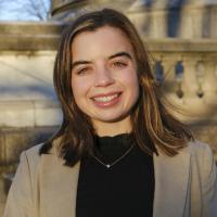 Headshot of student Carly T in gray blazer and black shirt with highlights in her hair